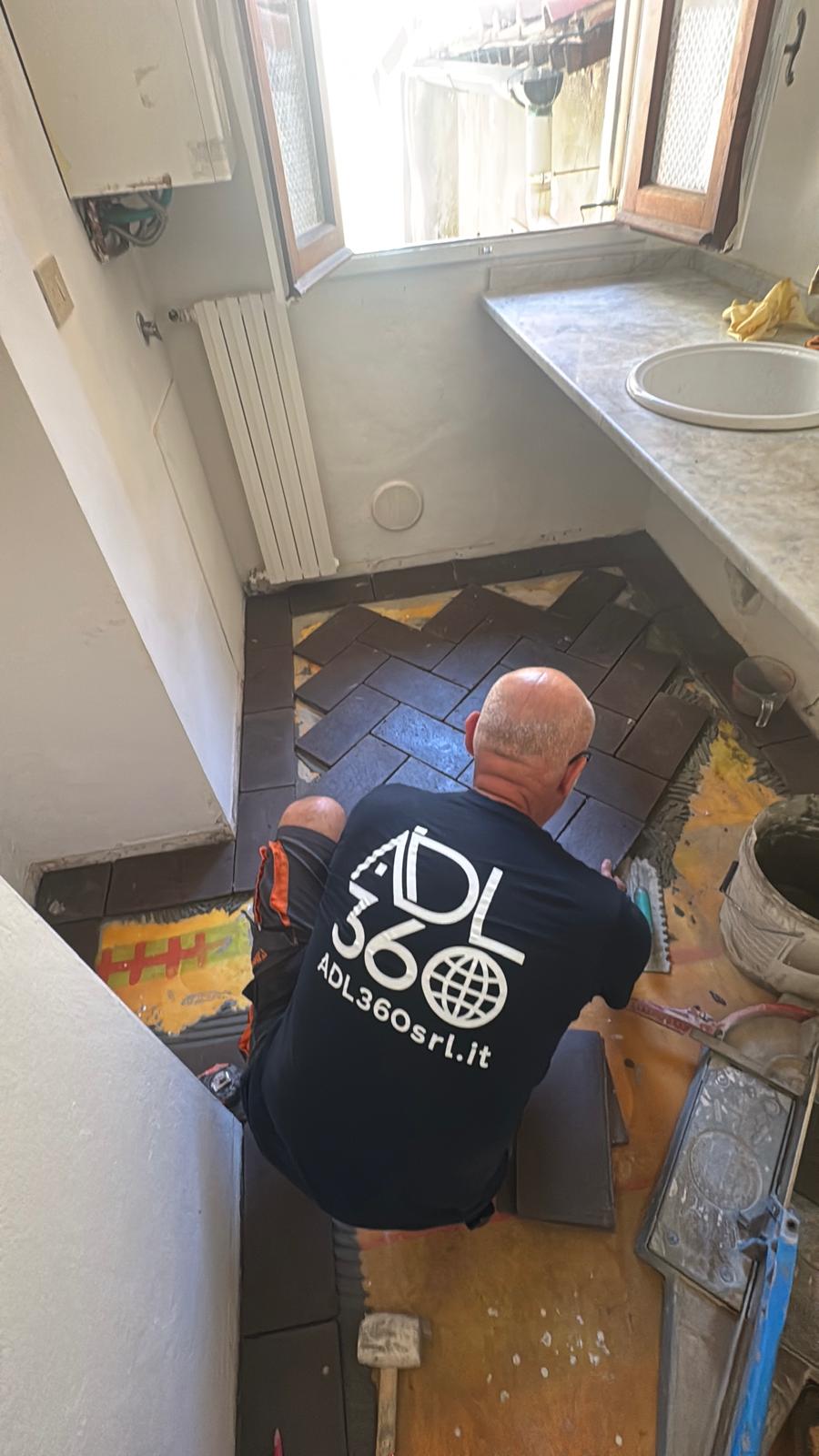 Piastrellista a Firenze durante la posa di pavimento in gres porcellanato a spina di pesce